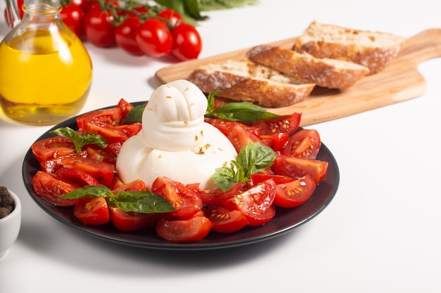 Traditional Italian burrata cheese with salad of delicious cherry tomato, basil leaves and olive oil