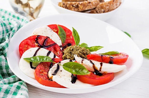 Traditional Italian Caprese Salad with mozzarella, tomato, basil and balsamic vinegar