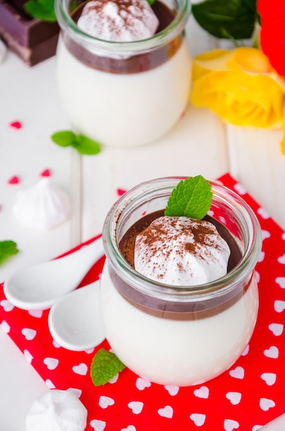 Traditional Italian dessert panna cotta with chocolate sauce and crispy meringue