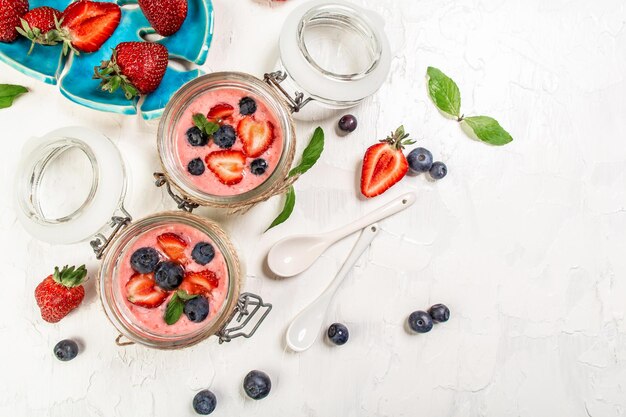 Traditional Italian dessert panna cotta with fresh berries Summer yogurt dessert with mint leaves vertical image top view