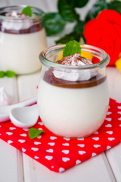 Traditional Italian dessert pannacotta with chocolate sauce and crispy meringue