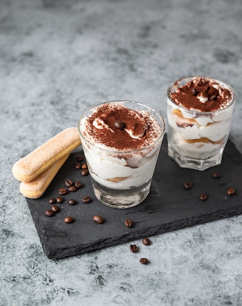 Traditional Italian dessert tiramisu Portion dessert made of savoiardi and mascarpone with cocoa