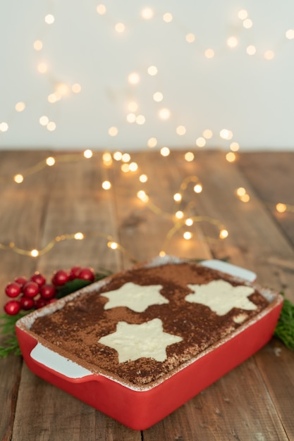 Traditional Italian dessert. Tiramisu with Christmas decoration. Vertical format. Copy space.