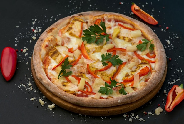 Traditional Italian pizza with ham cheese and tomatoes on a dark background