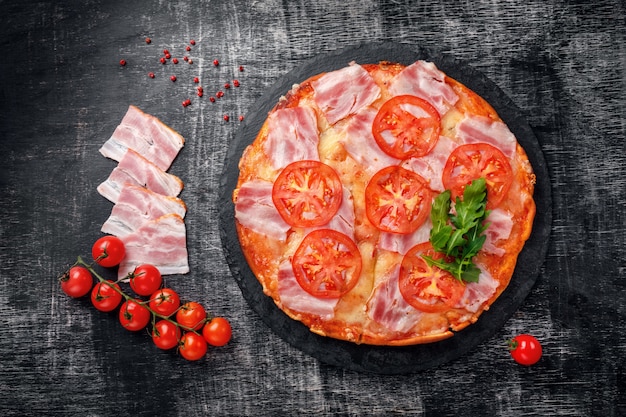 Traditional italian pizza with mozzarella cheese, ham, tomatoes, pepper, pepperoni spices and fresh rucola