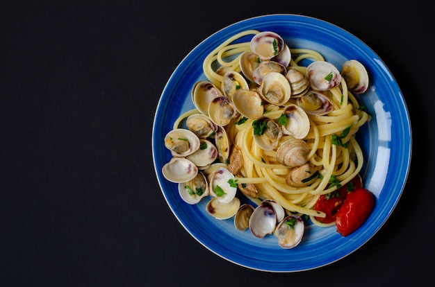 Traditional italian seafood concept. Spaghetti with clams or shelfish, tomato and herbs