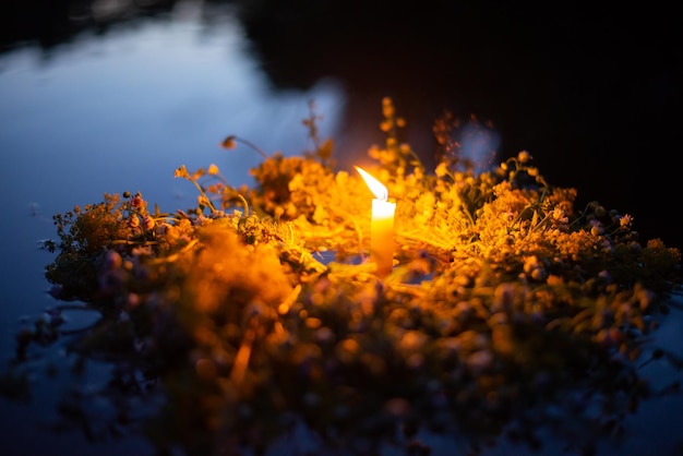 Traditional Ivana Kupala wreath flowing on the river with bright candle in the middle Celebrating day of Ivana Kupala in Ukraine