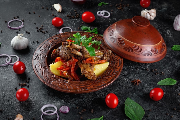 Traditional Kazakh dish Kuirdak Aromatic roast of byproducts lamb meat with lots of onions and vegetables in a clay pot