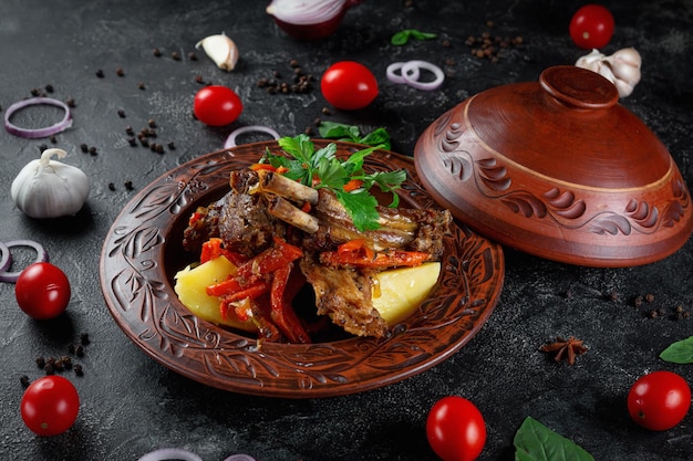 Traditional Kazakh dish Kuirdak Aromatic roast of byproducts lamb meat with lots of onions and vegetables in a clay pot