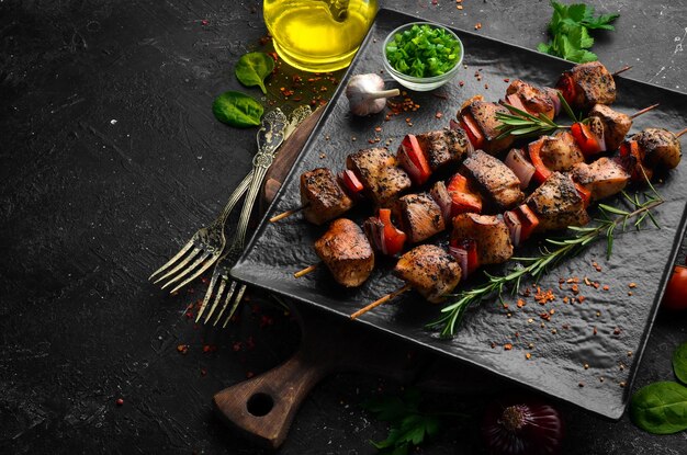 Traditional Kebab Juicy chicken kebab with vegetables on a black stone plate Barbecue Top view Free space for text