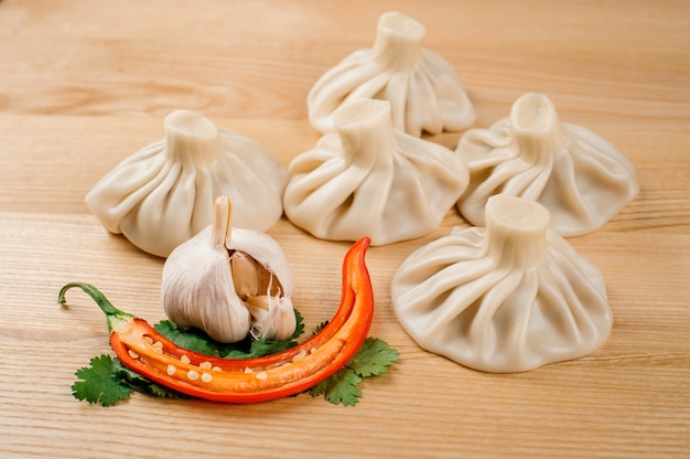 Traditional khinkali with pepper, garlic and parsley are laying on the table