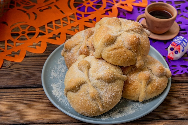 Traditional Mexican bread of the dead also known as Pan de Muerto on traditional Mexican table home