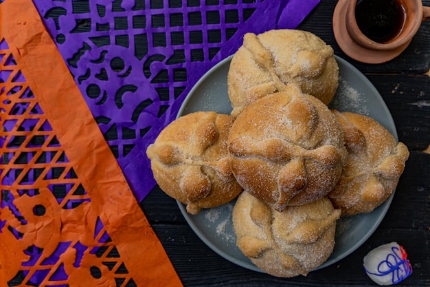 Traditional Mexican bread of the dead also known as Pan de Muerto on traditional Mexican table home