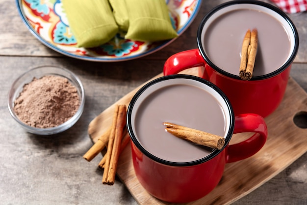 Traditional Mexican chocolate atole drink on wooden table