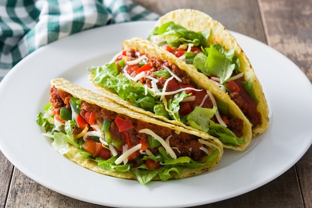 Traditional Mexican tacos with meat and vegetables on wood