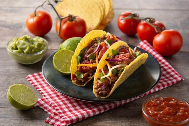 Traditional Mexican tacos with meat and vegetables on wooden table