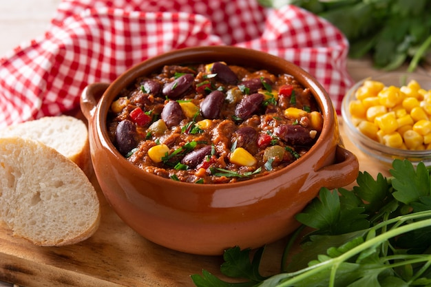 Traditional mexican tex mex chili con carne in a bowl on black background.