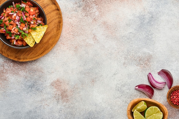 traditional mexican tomato sauce salsa with nachos and ingredients tomatoes, chile, garlic, onion