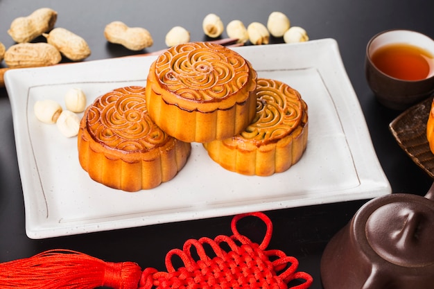 Traditional mooncakes on table setting with teacup.