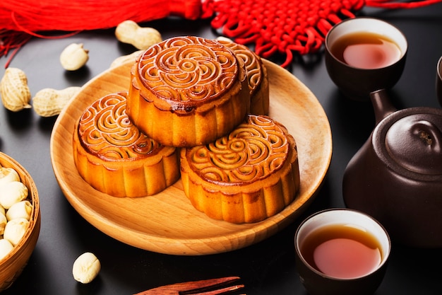 Traditional mooncakes on table setting with teacup.