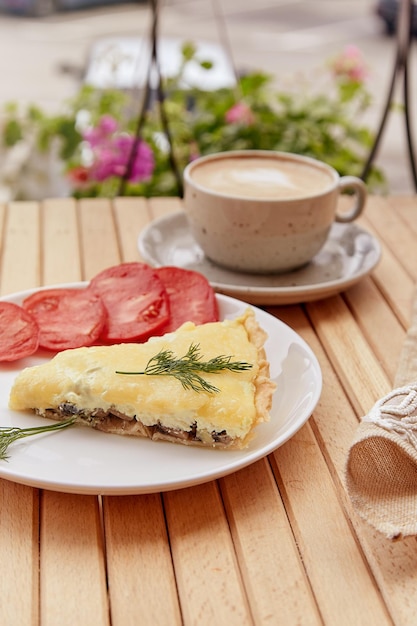 Traditional natural vegetarian pie with mushrooms and adyghe cheese tomatoes and dill Cup of coffee Healthy lunch French food