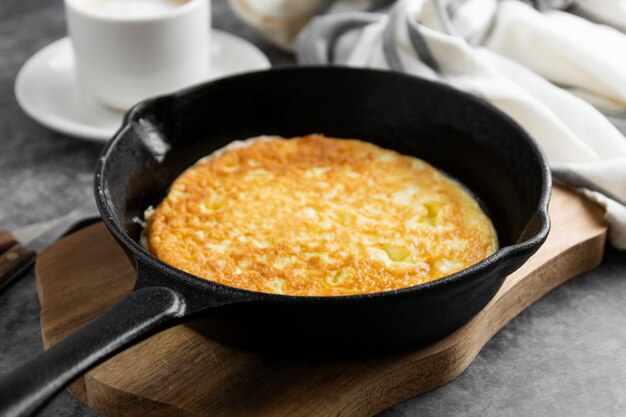 Traditional omelette on black frying pan in black, skillet black pan, dark food photo.