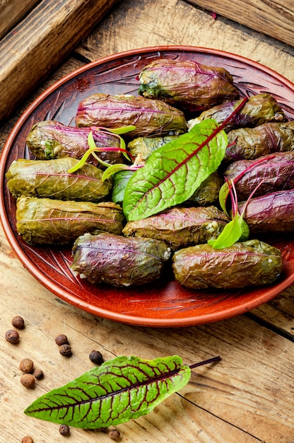 Traditional oriental dolma in sorrel leaves on rustic wooden table