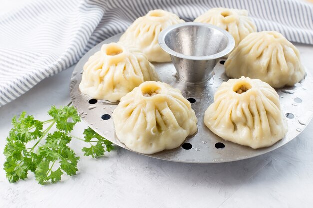 Traditional oriental food manti with meat on an iron mantovark