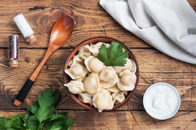 Traditional pelmeni ravioli dumplings filled with meat on plate russian kitchen Wooden rustic background copy space