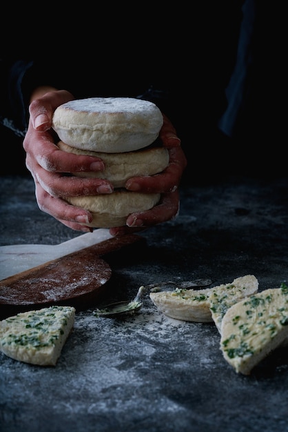 Traditional Portuguese flat circular bread Bolo Do Caco. Female hands holding stack of the bread. Selective focus