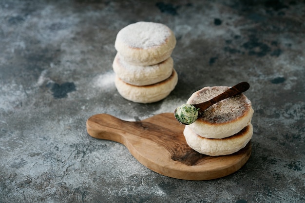 Traditional Portuguese flat circular bread Bolo Do Caco. Spoon of garlic butter with greens on the top. Madeira island cuisine.