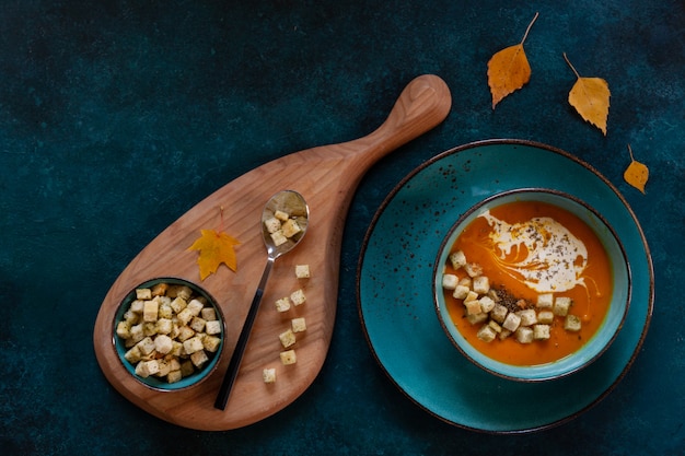 Traditional pumpkin homemade cream-soup with croutons and thyme