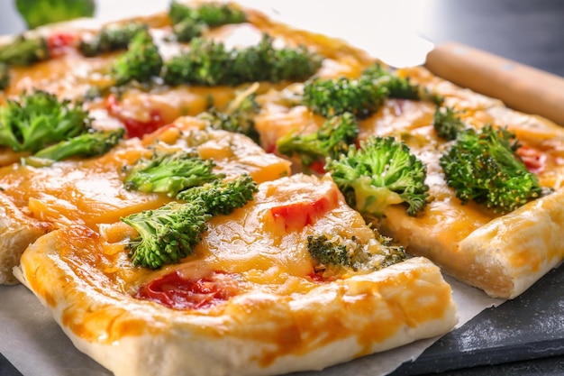 Traditional quiche with broccoli and cheese on table close up