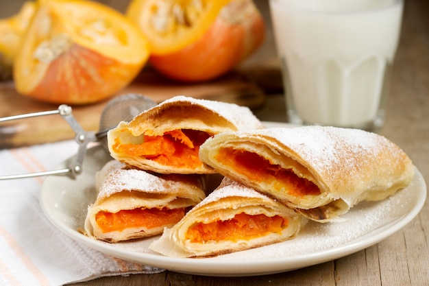 Traditional Romanian or Moldovan pumpkin strudel vertuta served with milk. Rustic style.