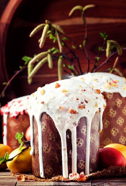 Traditional Russian Easter cake Kulich with colored golden yellow eggs decorated with candied fruits