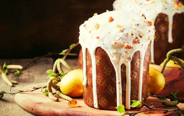 Traditional Russian Easter cake Kulich with colored golden yellow eggs decorated with candied fruits