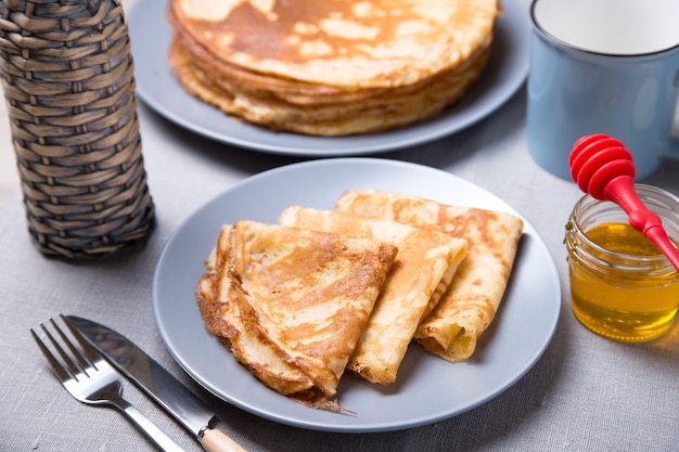 Traditional Russian pancakes with honey. Shrovetide. Maslenitsa week. Selective focus, close-up.