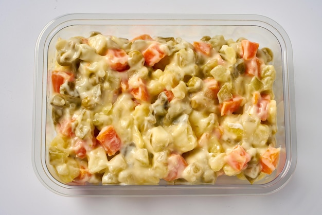 Traditional Russian salad Olivier from boiled vegetables with mayonnaise in a bowl.