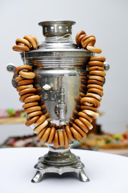 Traditional Russian samovar with a bunch of bagels in white light room