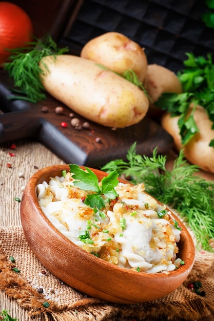 Traditional Russian vareniki with potatoes and fried onions in bowl on old wooden table rustic style selective focus