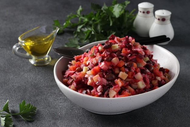 Traditional salad Vinaigrette of beets potatoes carrots beans pickles onions and vegetable oil on dark gray background Vegetarian food