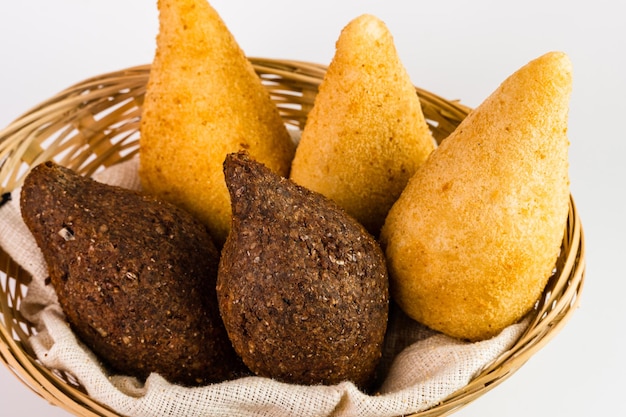 Traditional snacks Chicken Coxinha known as Coxinha in Brazil and Fried Kibe Served in a basket White background Selective focus