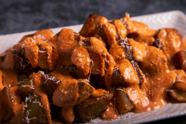 Traditional Spanish baked potato with spicy sauce Bravas dip Front view Close up