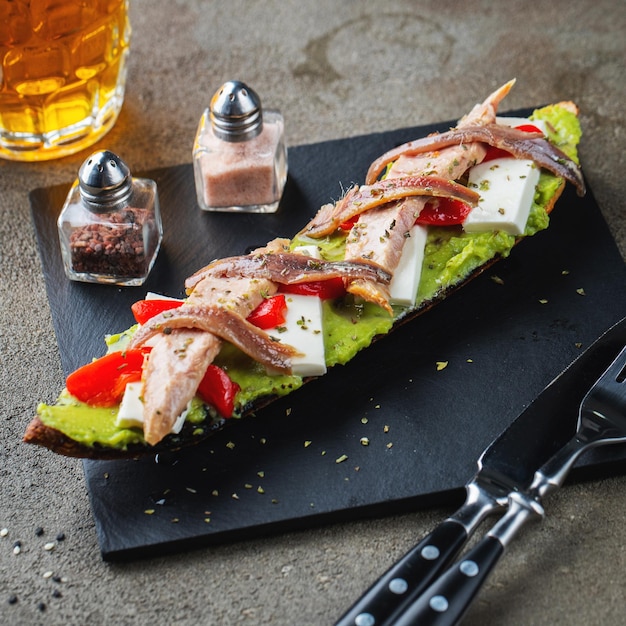 Traditional Spanish breakfast Tostada with different toppings on a dark background