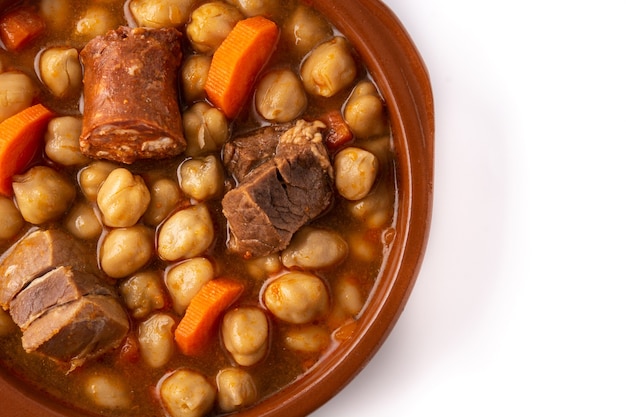 Traditional Spanish cocido madrileÃÂ±o in bowl isolated on white background.