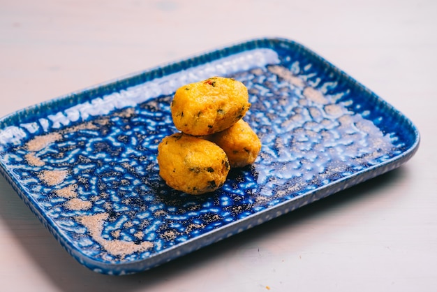 Traditional Spanish croquettes or croquetas on a blue plate. Tapas food.