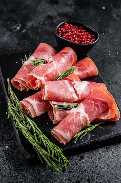 Traditional Spanish Jamon Serrano ham on marble board Black background Top view