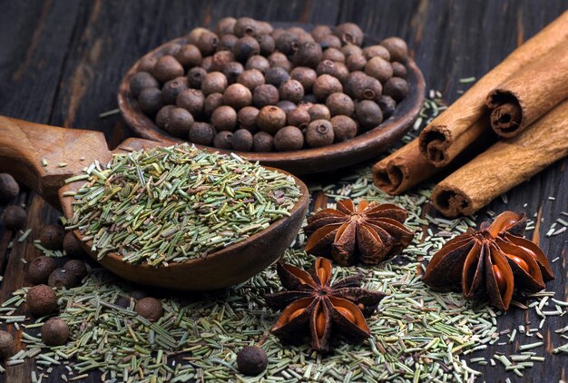 traditional spices. rosemary, allspice, cinnamon and anise on a wooden table