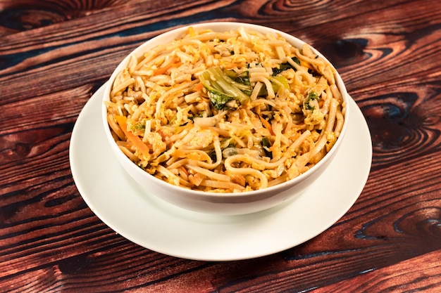 Traditional Spicy chow mein in a bowl isolated on marble background top view of chinese noodles