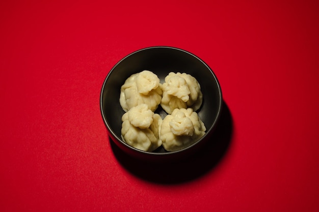 Traditional steamed dumplings khinkali on the red background